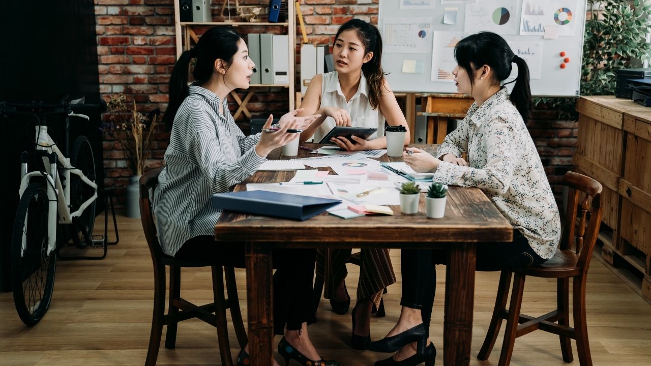 three asian women discussing